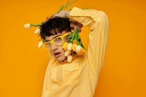 Foto av romantisk ung pojkvän med en modern frisyr i gul shirts med blommor gul bakgrund oförändrad