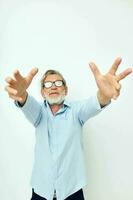 Foto av pensionerad gammal man i blå shirts gester med hans händer isolerat bakgrund