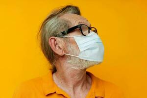 äldre man medicinsk mask på de ansikte skydd närbild isolerat bakgrund foto