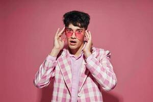 porträtt av en ung man pläd blazer rosa glasögon mode modern stil isolerat bakgrund oförändrad foto