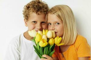 söt eleganta barn med en bukett av blommor gåva födelsedag Semester barndom ljus bakgrund foto