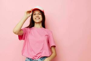 ung flicka i en rosa t-shirt med en keps på henne huvud tillfällig ha på sig foto