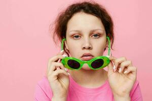 eleganta tonåring flicka modell mode grön glasögon rosa t-shirt dekoration Framställ foto