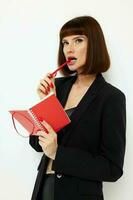 porträtt av en kvinna kort håriga röd anteckningsblock och penna ljus bakgrund foto