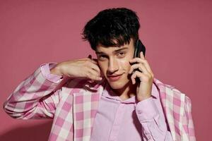 Söt man modern talande på de telefon rosa blazer Framställ studio livsstil oförändrad foto