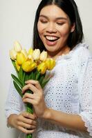 charmig ung asiatisk kvinna i en vit skjorta blommor vår Framställ livsstil oförändrad foto