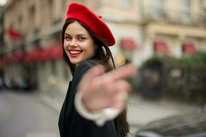 mode kvinna leende med tänder stående på de gata i främre av de stad turist Följ mig eleganta kläder med röd mun och röd basker, resa, filmiska Färg, retro årgång stil, urban mode. foto