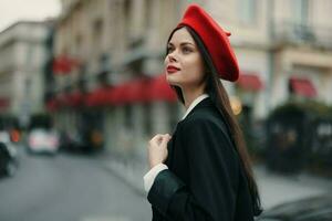 mode kvinna porträtt skönhet stående på de gata i främre av de stad i eleganta kläder med röd mun och röd basker, resa, filmiska Färg, retro årgång stil, urban mode livsstil. foto