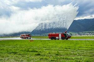 brand stridande med vatten spray. brand lastbil och brand motor med brand män. nödsituation och brand. brand katastrof och kris. foto