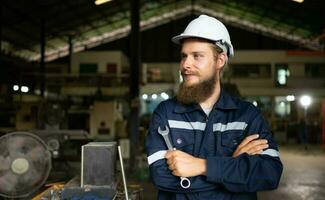 porträtt av mekanisk ingenjörer är kontroll de arbetssätt tillstånd av ett gammal maskin den där har varit Begagnade för några tid. i en fabrik var naturlig ljus lyser till de arbetsplats foto