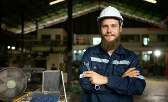 porträtt av mekanisk ingenjörer är kontroll de arbetssätt tillstånd av ett gammal maskin den där har varit Begagnade för några tid. i en fabrik var naturlig ljus lyser till de arbetsplats foto