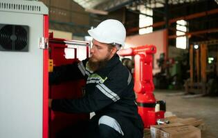 elektrisk ingenjör med de uppdrag av montera en robot ärm elektrisk systemet foto