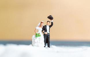 miniatyrfolk, lyckliga bröllopspar på en vit strand, bröllopskoncept foto