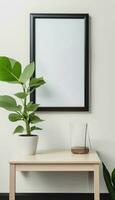 Foto en inramade bild är på en vit vägg Nästa till en små tabell och en växt