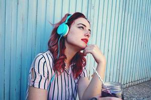 vacker rödhårig kvinna lyssnar på musik foto