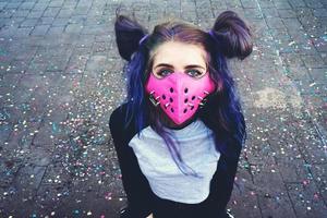 ung punk kvinna som bär en rosa mask foto