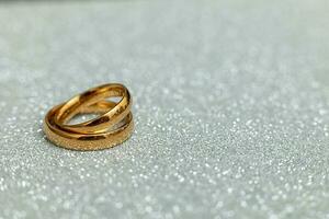 kommer du gifta sig mig. två gyllene bröllop ringar på silver- glitter bakgrund. engagemang äktenskap förslag bröllop begrepp. st. hjärtans dag vykort. baner på valentines dag. kopia Plats. foto