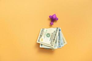 leksak luft plan med kontanter pengar topp se, platt lägga på orange bakgrund. foto