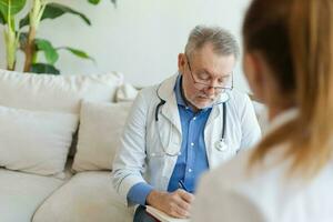 senior man läkare granskning yound kvinna i läkare kontor eller på Hem. flicka patient och läkare ha samråd i sjukhus rum. medicin sjukvård medicinsk kolla upp. besök till läkare. foto