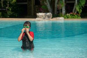 asiatisk liten flicka i en baddräkt simning på de simning slå samman foto