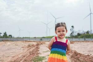 asiatisk flickor studie vind turbiner till generera elektricitet. hållbar energi. framtida. foto