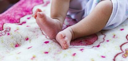 asiatisk nyfödd bebis fötter på vit filt. foto