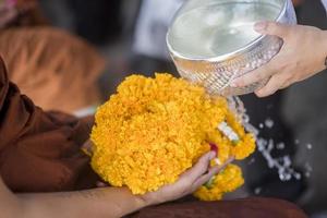 vatten i vatten skopa med färgglada blommor piedestal för songkran festival, thailand foto