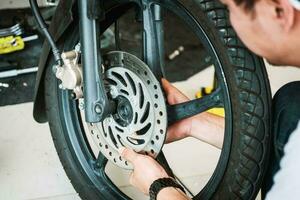 mekaniker ta bort och Installera de främre hjul på en motorcykel på garage, motorcykel reparera, underhåll och service begrepp foto