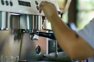 Barista kaffe maskin i Kafé selektiv fokus förbereda framställning varm kaffe espresso med professionell kaffe maskin. foto