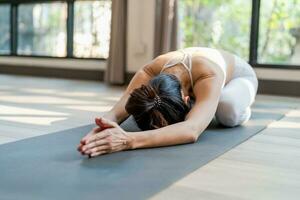 kvinna håller på med yoga stretching övning foto