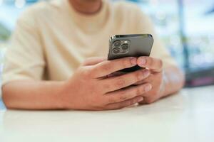 avslappnad ung asiatisk man använder sig av smart telefon utgifterna tid kontroll Nyheter social media. foto