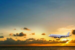 kommersiell flygplan ovan hav med solnedgång i sommar säsong över skön landskap hav bakgrund, begrepp företag resa och transport sommar semester resa. foto