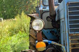 del av en blå traktor på skog bakgrund. foto