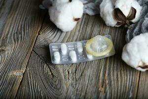 preventivmedel piller och kondom på en trä- yta. foto
