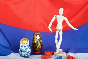 trä- siffror, ryska matryoshka och trä- dummy figurer på ryska flagga. foto