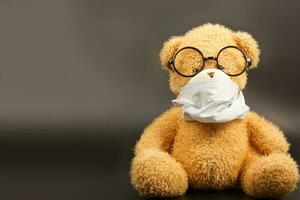 en plysch teddy Björn i en medicinsk mask foto