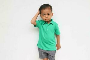porträtt av en förvirrad liten asiatisk pojke se olycklig, isolerat på de vit bakgrund foto