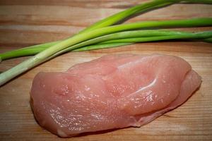 kycklingfilé med grönsaker på en skärbräda foto