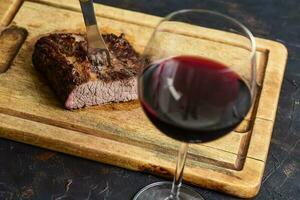 rostad nötkött revben med en glas av röd vin presenteras på de tabell, traditionell argentine kök, asado utegrill, patagonien, argentina. foto