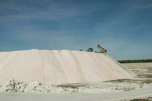 lastbilar avlastning rå salt bulk, saliner grandes de hidalgo, la pampa, patagonien, argentina. foto