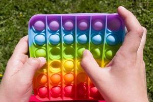 färgglada anti-stress sensoriska fidget push pop det leksak i barns händer