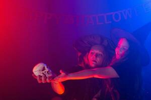 två halloween häxor framställning en trolldryck och trolla i halloween natt. magi, högtider och mystiker begrepp. foto