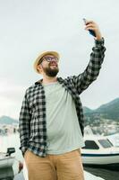 resande man tar selfie av lyx yachter marin under solig dag - resa och sommar begrepp foto