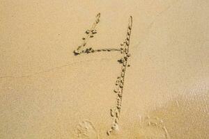 de siffra fyra dragen på sand på de strand, Semester begrepp bakgrund foto