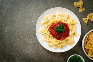 farfalle pasta i tomatsås med persilja - italiensk matstil foto