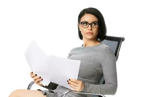 fundersam ung företag kvinna i glasögon Sammanträde på kontor stol med papper dokument. isolerat över vit bakgrund. .prestation företag karriär begrepp. foto