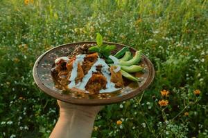 i Mexiko, traditionell chilaquiles är eras på en tabell med färgrik dishware och färsk Ingredienser. foto