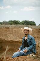 cowboy under de omfattande himmel, omgiven förbi kaktusar, arbetssätt på en bruka foto