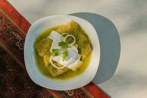 de mexikansk enchilada verdes, en häfta mat i mexikansk kök, är eras på en tallrik foto