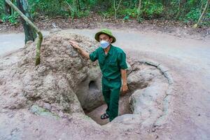 cu chi, viet nam - 20 Maj 2023 de cu chi tunnlar. en guide demonstrera på vilket sätt en vietcong Dölj in i de tunnel. dess Begagnade i vietnam krig. känd turist attraktion i vietnam. stock Foto